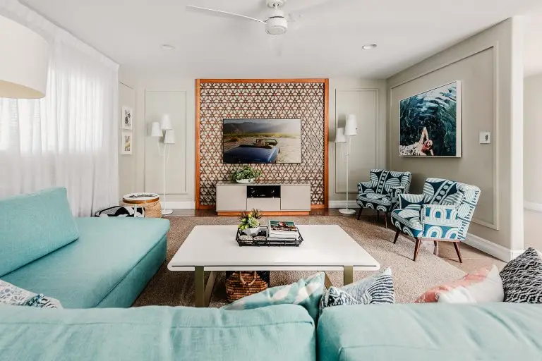 Mid-century inspired living room at Biskra House with turquoise sectional sofa, patterned chairs, and custom wood lattice wall in Rancho Mirage, California.