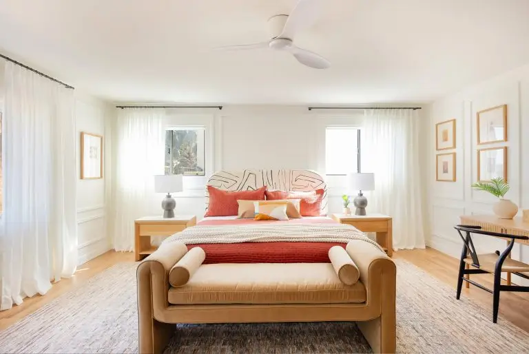 Bright and airy primary bedroom at Biskra House with abstract upholstered headboard, coral bedding, and natural wood furniture in Rancho Mirage, CA.