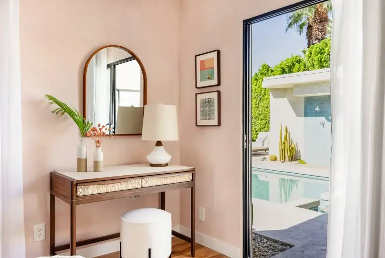 Poolside twin bedroom with pink plaster walls and vanity area overlooking the courtyard pool at Biskra House.